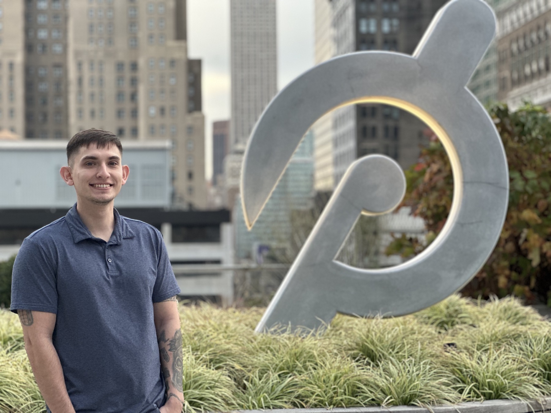 James Sedlacek standing beside the Peloton logo in New York City